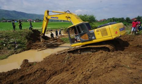 Petugas mengoperasikan alat berat untuk memperbaiki tanggul jebol di Desa Pojok, Campurdarat, Tulungagung, Jawa Timur, Kamis (4/2/2021). Perbaikan darurat tanggul jebol tersebut dilakukan untuk mencegah banjir susulan yang mengancam ratusan rumah penduduk dan puluhan hektare sawah.