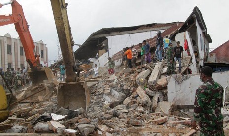 Officers operate heavy equipment to search for victims of the rubble of houses store (shop) caused by the earthquake in the village of Ulee Glee, Bandar Dua Sub-district, Pidie Jaya, Aceh, Wednesday (12/7).