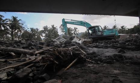 Petugas mengoperasikan ekskavator untuk membersihkan material Gunung Semeru yang menutupi jalan. Sebagian peserta calon anggota PPK naik pengeruk ekskavator demi ikuti tes. Ilustrasi.