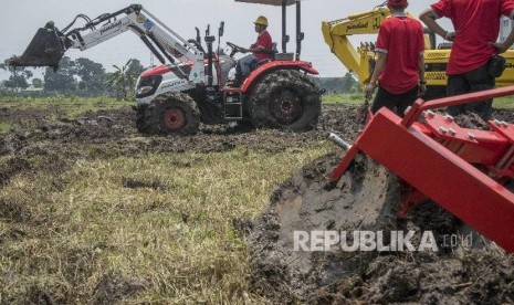 Petugas mengoperasikanTraktor Multiguna Roda 4 (PTM45) produksi PT Pindad di persawahan kawasan Sekejati, Bandung, Jawa Barat, Kamis (1/3).