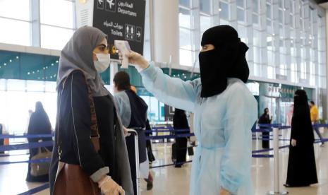 Omicron, Arab Saudi Tutup 14 Penerbangan Negara Afrika. Petugas mengukur suhu penumpang di Bandara Internasional Riyadh, Arab Saudi.