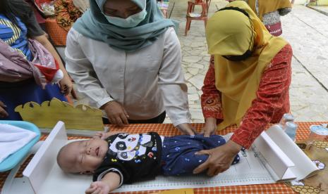 Petugas mengukur tinggi badan balita untuk mencegah kasus stunting saat pelaksanan Pos Pelayanan Terpadu (posyandu) di Kedaton, Kota Bandar Lampung, Provinsi Lampung, Senin (21/3/2022). 