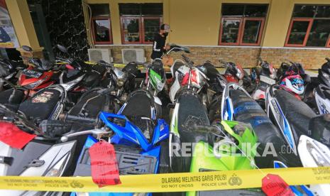 Petugas mengumpulkan barang bukti saat rilis kasus pencurian kendaraan bermotor (curanmor) di Polres Indramayu, Jawa Barat, Rabu (26/1/2022). Polres Indramayu mengamankan tujuh orang penadah serta pelaku pencurian kendaraan bermotor lintas daerah dengan barang bukti 25 unit kendaraan roda dua dan tersangka dikenakan pasal 363 KUHP dan 480 KUHP dengan ancaman hukuman maksimal tujuh tahun penjara. 