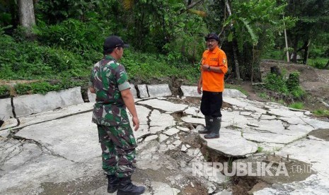 Petugas meninjau retakan akibat pergerakan tanah, di Desa Bantarkalong, Kecamatan Warungkiaraerjadi, Kabupaten Sukabumi, Senin (7/2). Dalam peristiwa tersebut, sejumlah rumah warga mengalami kerusakan.