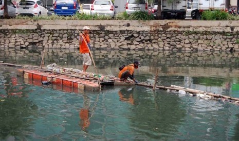   Petugas menjaring sampah di Kali Sunter Jakarta Utara, Jumat (14/3).   (foto :Raisan Al Farisi)