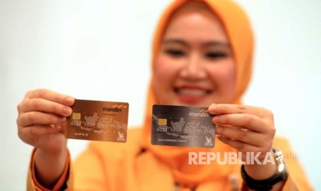 Petugas menunjukan kartu Mandiri Debit berlogo Gerbang Pembayaran Nasional (GPN) di kantor layanan Bank Mandiri, Jakarta, Senin (9/4). Bank Mandiri memperkenalkan kartu Mandiri Debit berlogo GPN untuk meningkatkan efisiensi dan menekan biaya transaksi antarbank.