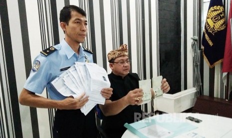 Officer was showing a written statement from the representative of UNHCR which confirmed the owner of the cards are asylum seekers. Those cards belongs to Iraqi migrants at the Immigration Office Class II, Sukabumi, West Java, Monday (10/17). (Republika/Riga Nurul Iman)