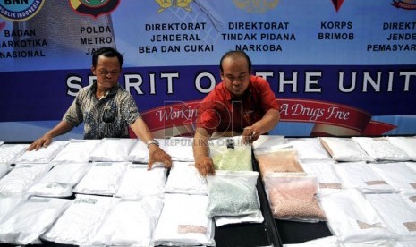  Petugas menunjukan ribuan barang bukti ekstasi yang berhasil disita di halaman Gedung Direktorat Tindak Pidana Narkoba Bareskrim Polri, Cawang, Jakarta Timur, Jumat (15/3).  (Republika/Prayogi)