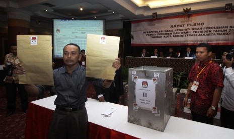 Petugas menunjukkan amplop tersegel yang berisi hasil rekapitulasi surat suara pilpres 2014 tingkat PPS dan PPK 