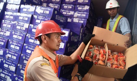 Petugas menunjukkan buah jeruk impor yang berada dalam Kontainer di Terminal Peti Kemas Surabaya, Jawa Timur, Jumat (4/3).