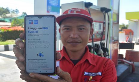 Petugas menunjukkan cara mendaftar di website sebelum membeli BBM bersubsidi di SPBU Kota Padangpanjang, Sumatera Barat, Jumat (1/7/2022). Pertamina menyosialisasikan mekanisme baru pembelian BBM bersubsidi dalam upaya memastikan penyaluran tepat sasaran, yakni dengan mendaftar melalui website subsidi.tepat.mypertamina.id khusus untuk kendaraan roda empat.