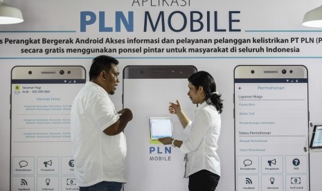 Petugas menunjukkan cara penggunaan aplikasi PLN Mobile kepada pengunjung saat peluncuran Aplikasi PLN Mobile. 