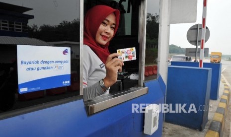 Petugas menunjukkan kartu BCA Flazz di gerbang Tol Cikopo KM 78 Jalan Tol Cikopo – Palimanan (Cipali), Kamis (31/3).