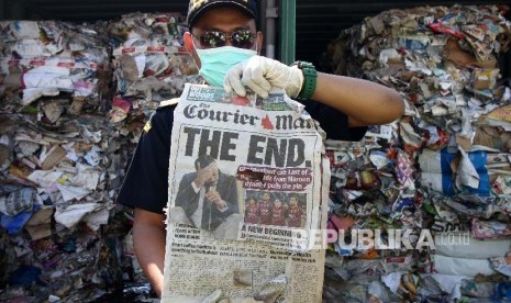 Petugas menunjukkan kertas bekas (waste paper) impor yang dikirim dari Australia di lapangan penumpukkan kontainer di PT Terminal Petikemas Surabaya (TPS) di Surabaya, Jawa Timur