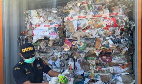 Petugas menunjukkan kontainer yang berisi sampah kertas impor Australia yang bercampur dengan sampah rumah tangga. Delapan kontainer berisi sampah dari Australia akan dipulangkan oleh Bea Cukai Tanjung Perak.