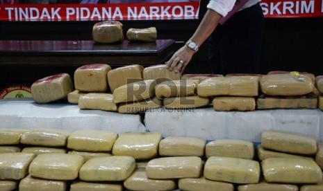  Petugas menunjukkan narkotika jenis ganja dan kurir saat rilis di Direktorat Tindak Pidana Narkoba (Dittipid Narkoba) Bareskrim Polri, Cawang, Jakarta, Senin (28/12). (Republika/Yasin Habibi)