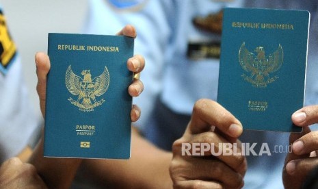 Petugas menunjukkan perbedaan Paspor Elektronik atau e-passport (kiri) 