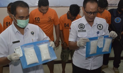 Petugas menunjukkan tersangka dan barang bukti kasus narkoba jenis Sabu saat rilis pengungkapan kasus narkoba jaringan Medan-Denpasar di Kantor Badan Narkotika Nasional (BNN) Provinsi Bali, Denpasar, Rabu (13/3/2019).