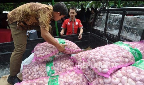 Petugas menurunkan ratusan kilogram bawang putih milik Bulog Sulawesi Tengah dari mobil pengangkut untuk dipasarkan pada pasar murah yang digelar di Palu, Sulawesi Tengah, Selasa (13/6). Menjelang perayaan Idul Fitri Bulog Sulawesi Tengah mendatangkan sekitar 20 ton bawang putih untuk selanjutnya dijual kepada masyarakat dengan harga lebih murah dibanding dipasaran guna menekan lonjakan harga bawang putih dipasaran yang menembus Rp 50.000 hingga Rp 60.000 perkilogram. 