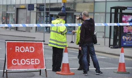 Petugas menutup jalanan sekitar Manchester Arena usai ledakan terjadi di sana saat konser Ariana Grande, Selasa (23/5).