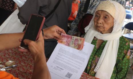 Petugas menyalurkan Bantuan Langsung Tunai (BLT) Bahan Bakar Minyak (BBM) dan Bantuan Pangan Non Tunai (BPNT) kepada seorang lansia di Kantor Pos Malang, Jawa Timur, Kamis (8/9/2022) (ilustrasi). PT Pos Indonesia (Persero) memberikan kemudahan dalam pengambilan bantuan sosial sembako dan Program Keluarga Harapan (Bansos Sembako-PKH) melalui kantor pos di seluruh Tanah Air bagi warga penerima.