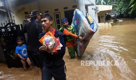 Petugas menyelamatkan barang-barang yang masih berharga saat banjir melanda permukiman bantaran Sungai Ciliwung di Jalan Gotong Royong, Kemirimuka, Beji, Depok, Jawa Barat, Senin (5/2).