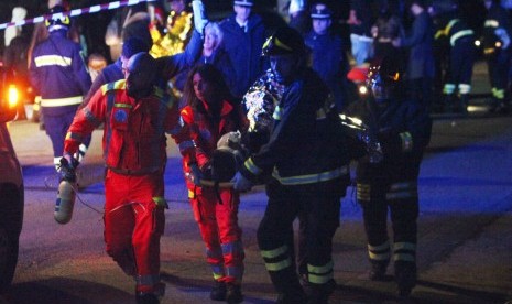 Petugas menyelamatkan korban runtuhnya jalan keluar klub malam Lanterna Azzurra di Kota Corinaldo, Ancona, Italia, Sabtu (8/12).