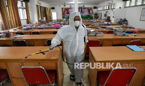 Petugas menyemprotan cairan disinfektan di SMAN 2, Kota Medan, Sumatera Utara, Jumat (11/2/2022). Penyemprotan dilakukan sebagai upaya pencegahan penularan COVID-19 di lingkungan sekolah pasca penutupan enam sekolah di Sumatera Utara akibat kasus COVID-19. 