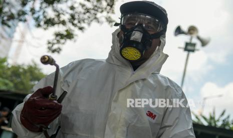 Petugas menyemprotkan cairan disinfektan, ilustrasi