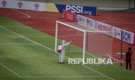 Petugas menyemprotkan cairan disinfektan ke tiang gawang sebelum pertandingan Piala Menpora di Stadion Manahan, Solo, Jawa Tengah, Ahad (21/3/2021). Piala Menpora dengan pertandingan pembuka Arema FC melawan Persikabo 1973 dilaksanakan tanpa penonton dan menerapkan protokol kesehatan ketat. 