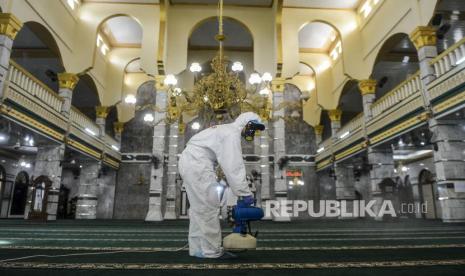 Petugas menyemprotkan disinfektan saat peluncuran Gerakan Semprot Disinfektan 10.000 Masjid.