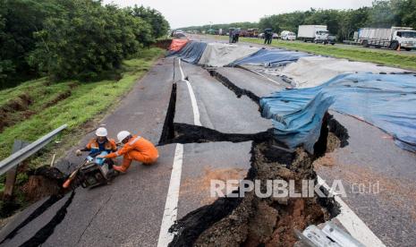 Petugas menyiapkan alat saat memeriksa kondisi jalan tol yang ambles di ruas tol Cikopo-Palimanan (Cipali) KM 122, Kabupaten Indramayu, Jawa Barat, Rabu (9/2/2021). Jalan tol Cipali KM 122 amblas pada hari Selasa (9/2) pukul 03.00 dinihari dan mengakibatkan penutupan jalan serta pemberlakuan lawan arah mulai dari KM 117 sampai KM 126.