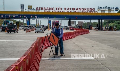 Petugas menyiapkan rambu lalu lintas guna pemberlakukan satu jalur (one way) di Tol Trans Jawa Km 414 Gerbang Tol Kalikangkung, Semarang, Jawa Tengah, Jumat (7/6/2019). 