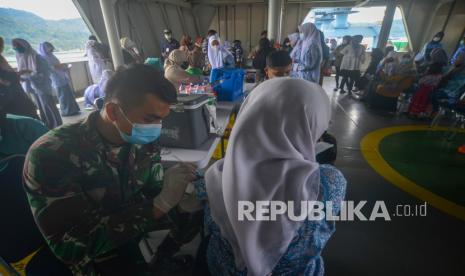 Petugas menyuntikan vaksin kepada seorang pelajar di atas KRI Bontang-907, di Pelabuhan Teluk Bayur, Padang, Sumatera Barat, Kamis (14/10/2021). Kedatangan KRI Bontang-907 ke Padang dalam rangka serbuan vaksin maritim dilaksanakan TNI-AL untuk membantu pemerintah mempercepat penyelesaian program vaksinasi COVID-19. 