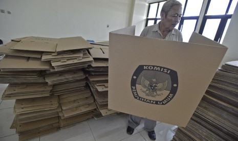  Petugas merapikan tumpukan kotak suara yang terbuat dari kardus di Kantor Kecamatan Tanjung Priok, Jakarta Utara, Rabu (19/2).   