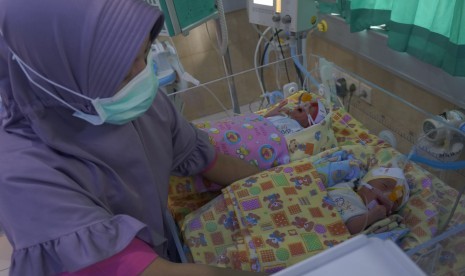 Petugas merawat dua dari tiga bayi kembar yang lahir prematur dengan bobot di bawah normal di ruang Neonatal Intensif care Unit (NICU) RSUD dr Iskak, Tulungagung, Jawa Timur, Kamis (8/11).