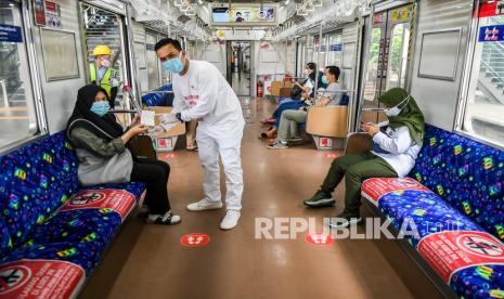 Petugas millenial KAI Commuter memberikan bunga dan healthy kit kepada perempuan pengguna KRL Commuter Line di Stasiun Jatinegara Baru, Jakarta, Selasa (22/12/2020). Memperingati Hari Ibu, PT KAI Commuter memberikan layanan istimewa khususnya perempuan dengan memberikan bunga dan healty kit sekaligus sosialisasi protokol kesehatan dengan menerapkan Adaptasi Kebiasaan Baru (AKB) di lingkungan stasiun dan di KRL. 