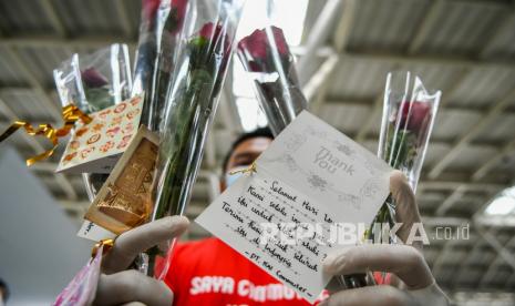 Petugas millenial KAI Commuter menunjukkan bunga dan healthy kit kepada perempuan pengguna KRL Commuter Line di Stasiun Jatinegara Baru, Jakarta, Selasa (22/12/2020). Memperingati Hari Ibu, PT KAI Commuter memberikan layanan istimewa khususnya perempuan dengan memberikan bunga dan healty kit sekaligus sosialisasi protokol kesehatan dengan menerapkan Adaptasi Kebiasaan Baru (AKB) di lingkungan stasiun dan di KRL. 