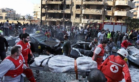  Petugas Palang Merah Lebanon mengevakuasi mayat di lokasi dua ledakan yang meledak dekat Kedutaan Besar Iran di Beirut, Lebanon, Selasa (19/11). (AP/Hussein Malla) 