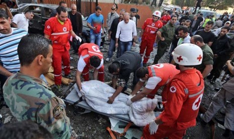 Petugas Palang Merah Lebanon mengevakuasi mayat di lokasi dua ledakan yang meledak dekat Kedutaan Besar Iran di Beirut, Lebanon, Selasa (19/11). (AP/Hussein Malla)