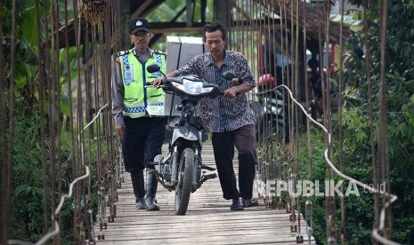 Petugas Panitia Pemungutan Suara (PPS) yang mendapat pengawalan polisi mendistribusikan kotak suara dan bilik suara Pilkada Jawa Tengah 2018 ke dua tempat pemungutan suara (TPS) di Dusun Sapen dan Dusun Borangan, Desa Candirejo, Pringapus, Kabupaten Semarang, Selasa (26/6).