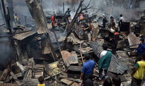  Petugas pemadam berupaya memadamkan sisa kobaran api saat musibah kebakaran perumahan padat penduduk yang terjadi di jalan Kerung-kerung, Bararayya Utara, Makassar, Makassar, Sulsel, Kamis (27/3). (Antara/Dewi Fajriani)