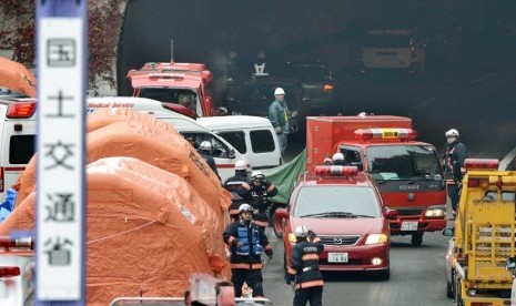 Petugas pemadam kebakaran bekerja di pintu keluar dari ruas terowongan Sasago dalam jalur Chuo Expressway di Jepang ,Senin (3/12).  (AP/Kyodo News) 