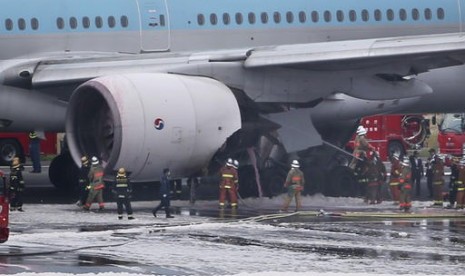 Petugas pemadam kebakaran bekerja memadamkan mesin pesawat Korean Air yang terbakar di Bandara Haneda, Tokyo, Jumat, 27 Mei 2016.