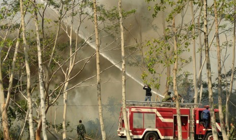 Petugas pemadam kebakaran bersama prajurit TNI memadamkan api yang membakar hutan di Kabupaten Aceh Besar, Aceh.