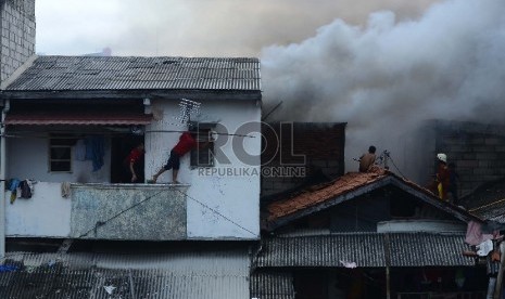  Petugas pemadam kebakaran bersama warga berusaha untuk memadamkan api yang membakar salah satu rumah di Kawasan Kebon Pala, Penjaringan, (Republika/Raisan Al Farisi) Jakarta Utara, Rabu (11/3).