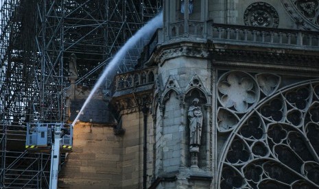 Petugas pemadam kebakaran berupaya memadamkan api di Katedral Notre-Dame di Paris, Prancis, Selasa (16/4).