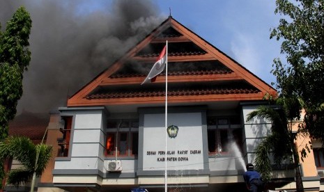 Petugas pemadam kebakaran berusaha memadamkan api saat kebakaran di kantor DPRD Kabupaten Gowa, Sulawesi Selatan, Senin (26/9). 