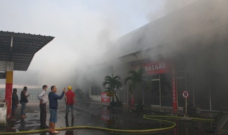 Petugas Pemadam Kebakaran berusaha memadamkan api yang membakar kios di Pasar Besar Malang, Jawa Timur, Kamis (26/5).