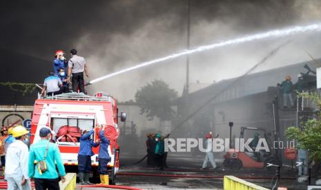 Petugas pemadam kebakaran berusaha memadamkan api yang membakar pabrik sepatu dan sandal di kawasan Buduran, Sidoarjo, Jawa Timur, Kamis (13/1/2022). Sebanyak sembilan unit mobil Pemadam Kebakaran (PMK) dikerahkan ke lokasi tersebut dan belum diketahui penyebabnya. 